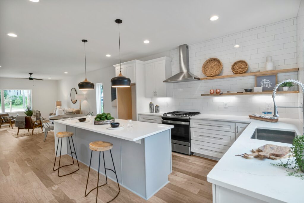 pexels photo 5502217 5502217 Spacious modern kitchen with island, white cabinets, and sleek lighting for a minimalist interior design.